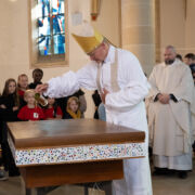 Bischof schüttet Chrisam-Öl auf den zukünftigen Altar
